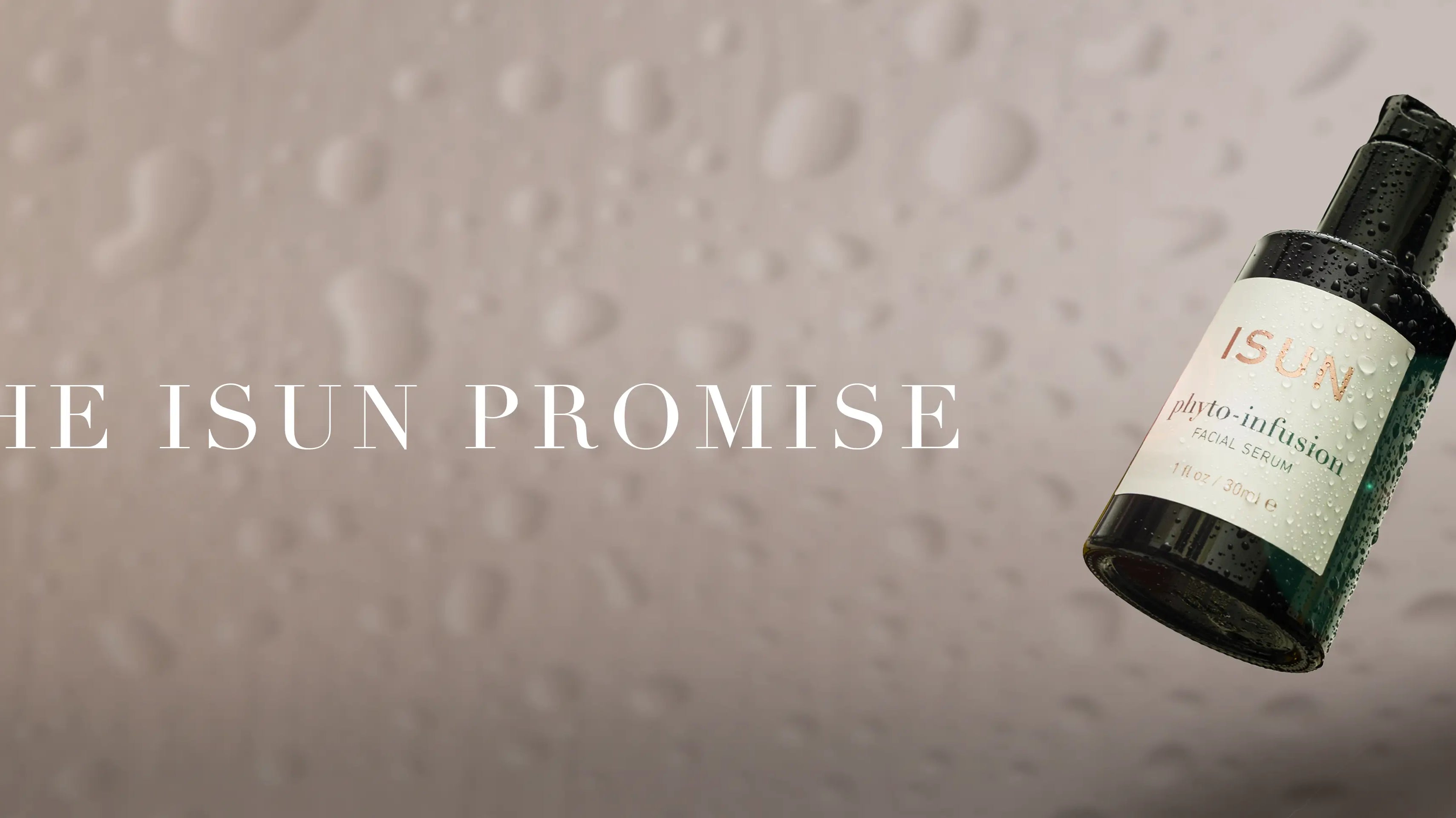 A bottle of Isun Phyto Infusion on a light background with water droplets and the words The ISUN Promise.