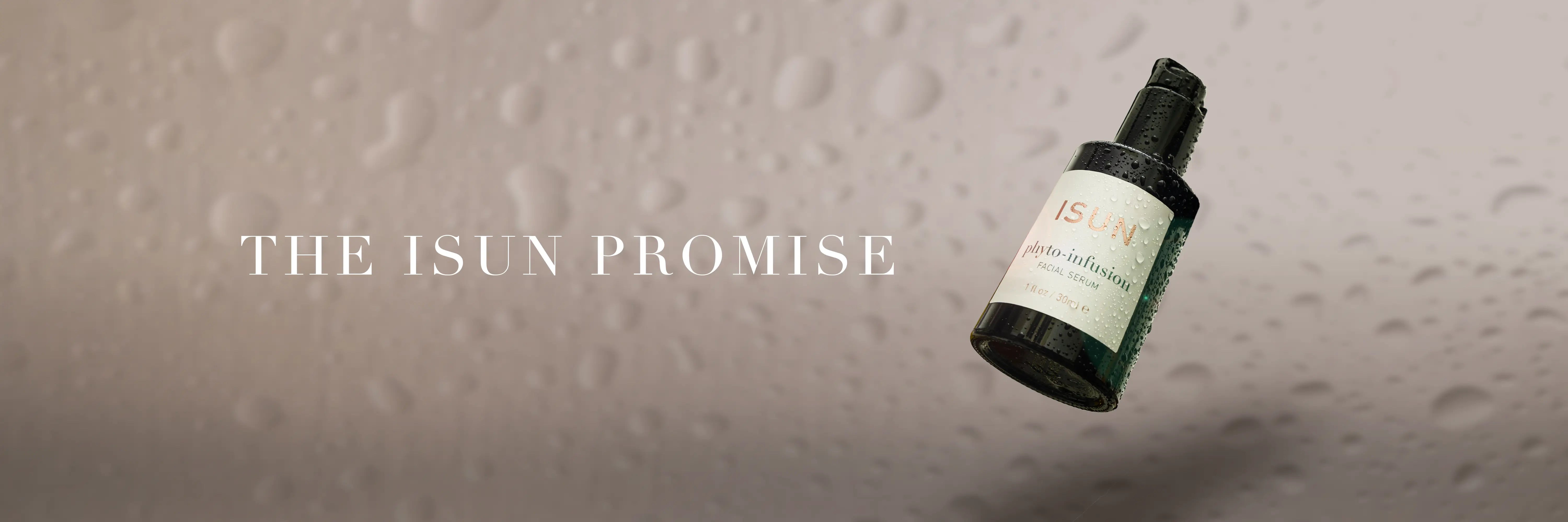 A bottle of Isun Phyto Infusion on a light background with water droplets and the words The ISUN Promise.