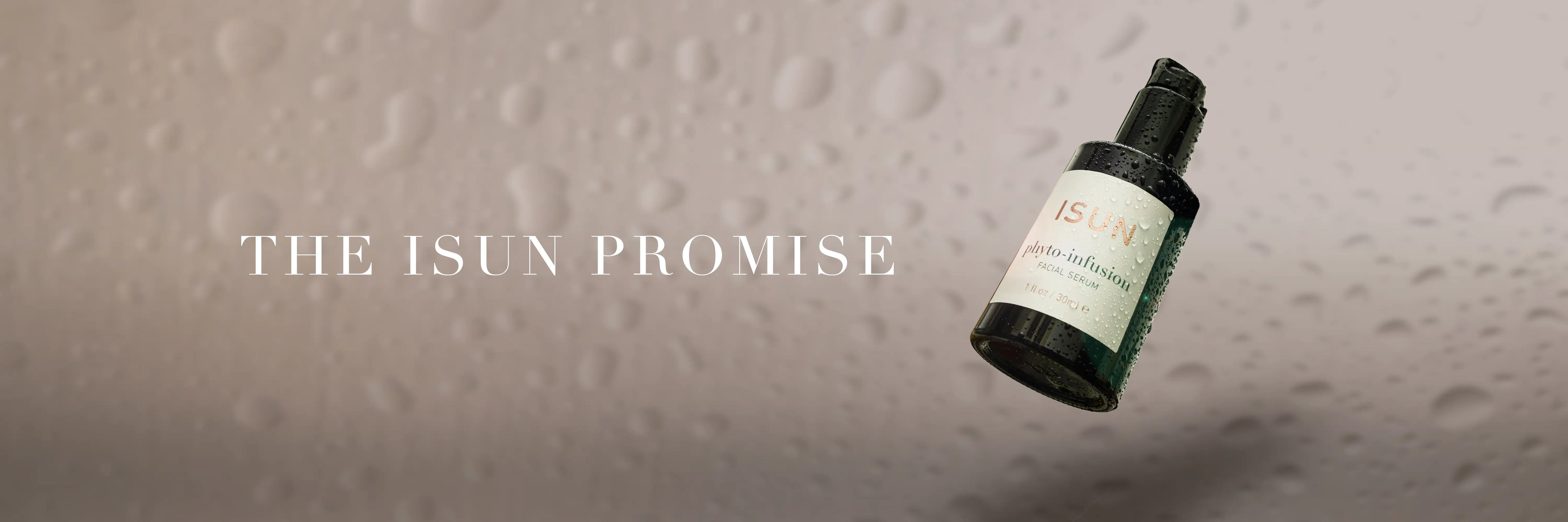 A bottle of Isun Phyto Infusion on a light background with water droplets and the words The ISUN Promise.