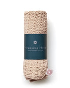 Beige crochet cleansing cloth with a teal green label on a white background