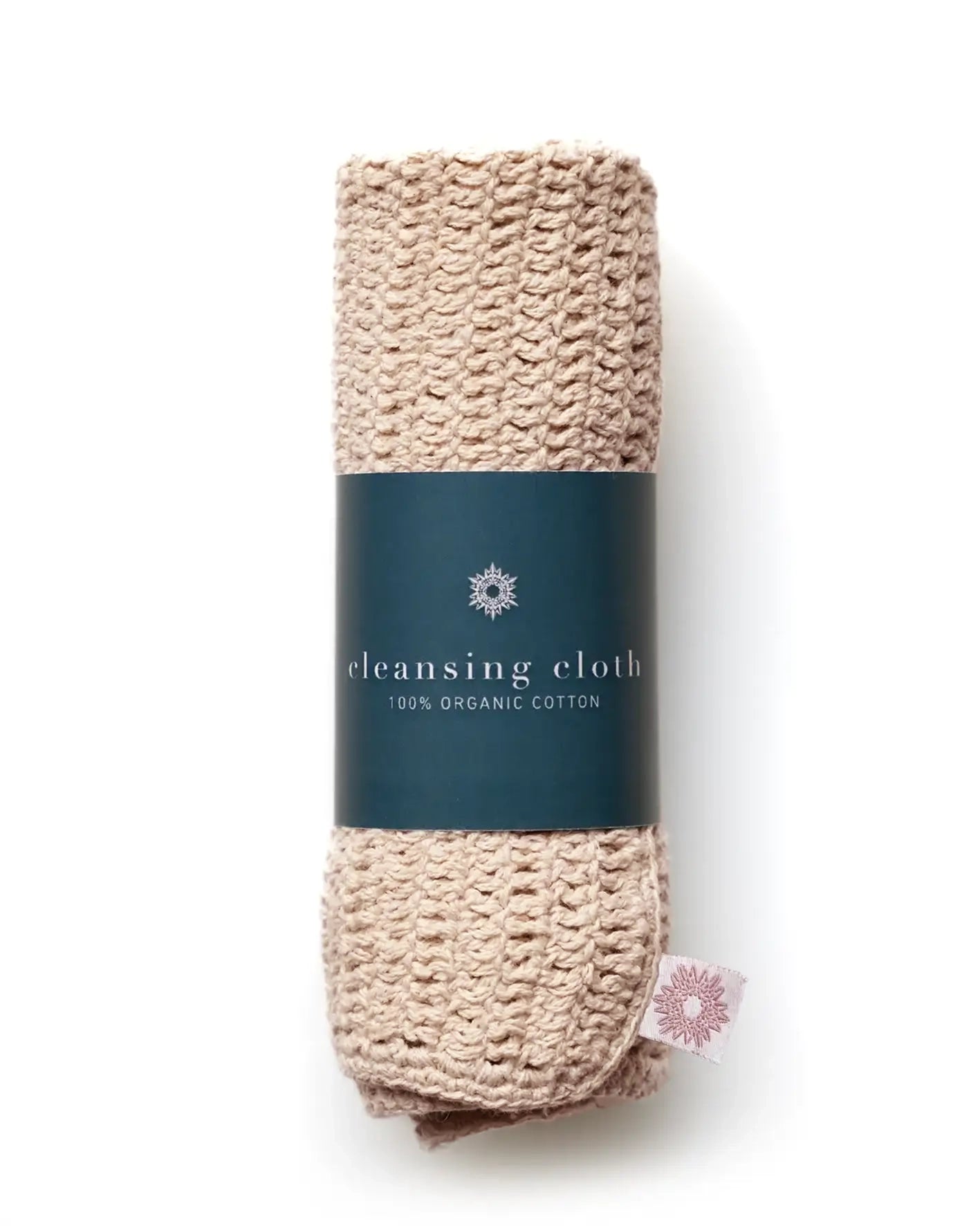 Beige crochet cleansing cloth with a teal green label on a white background