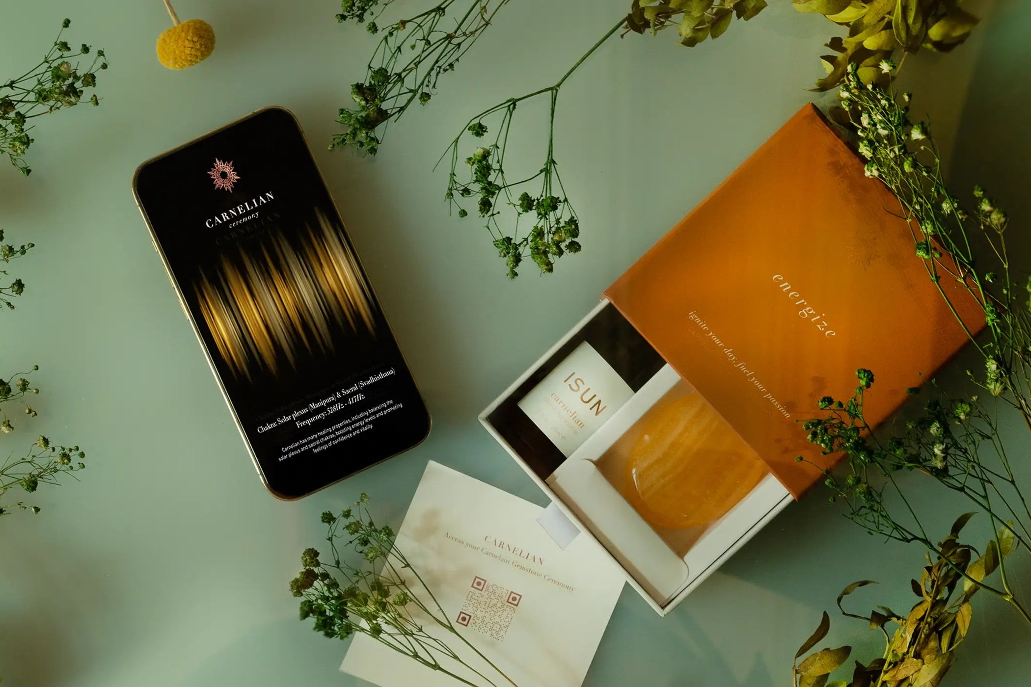 Phone with a floral design case on a light surface with flowers around