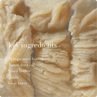 Close-up of a natural product with text listing key ingredients on a beige background