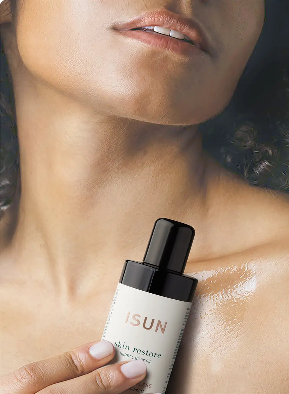 Hand holding a skincare product labeled 'ISUN' against a blurred background of a person's neck and shoulder.