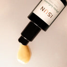 ISUN skincare serum bottle with a droplet of serum on a beige background