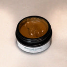 Jar of rhassoul-neem face mask on a beige background