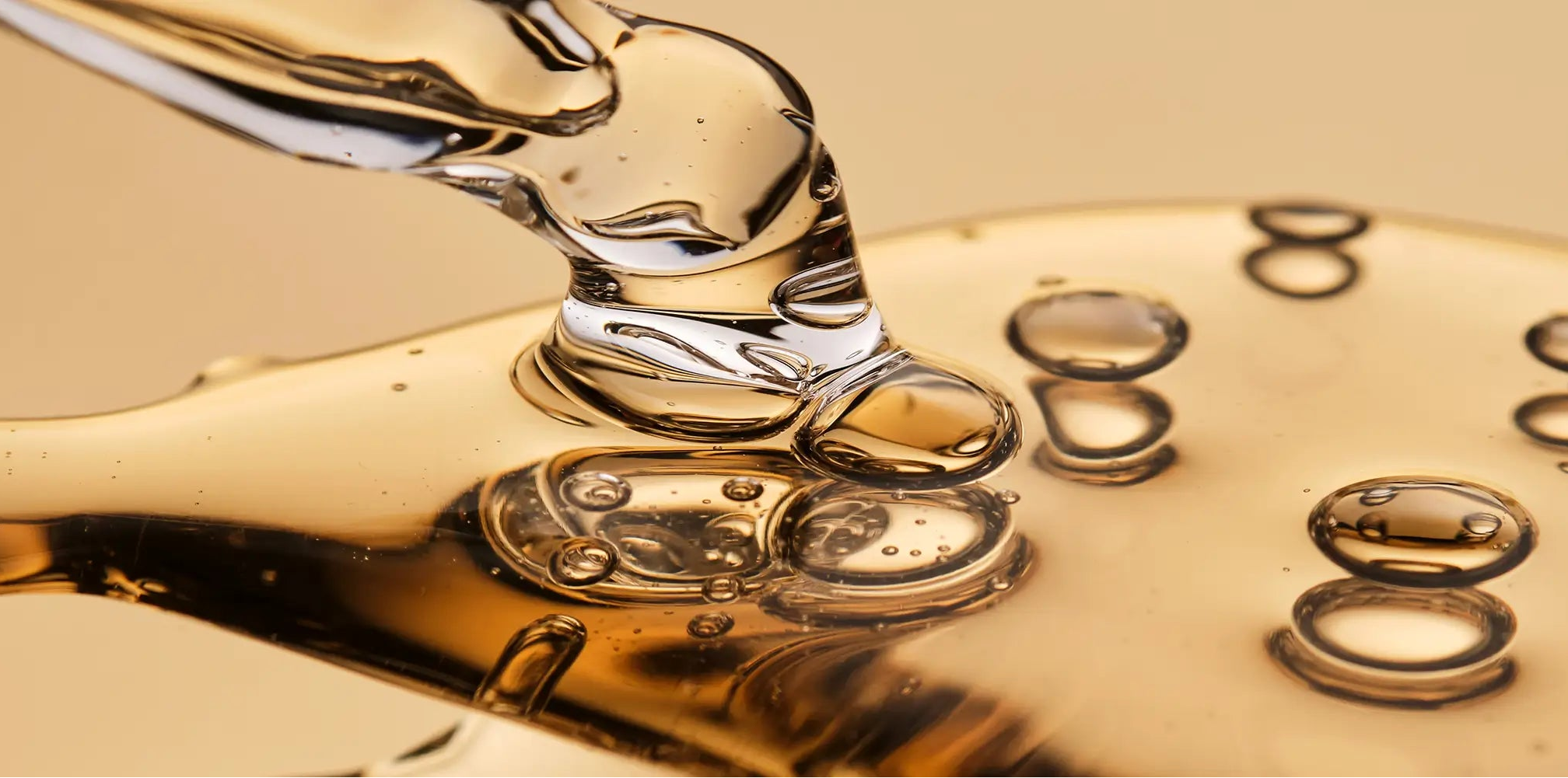 Close-up of a pipette with liquid droplets on a beige background