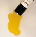 Yellow liquid spilling from a bottle labeled 'Sacred' on a white background