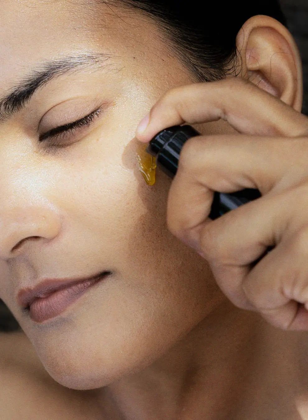 Person applying a cosmetic product to their face 