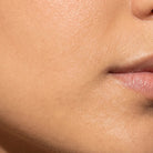 Extreme close-up of a person's lower face showing smooth skin texture, cheek, jawline, and part of the mouth.
