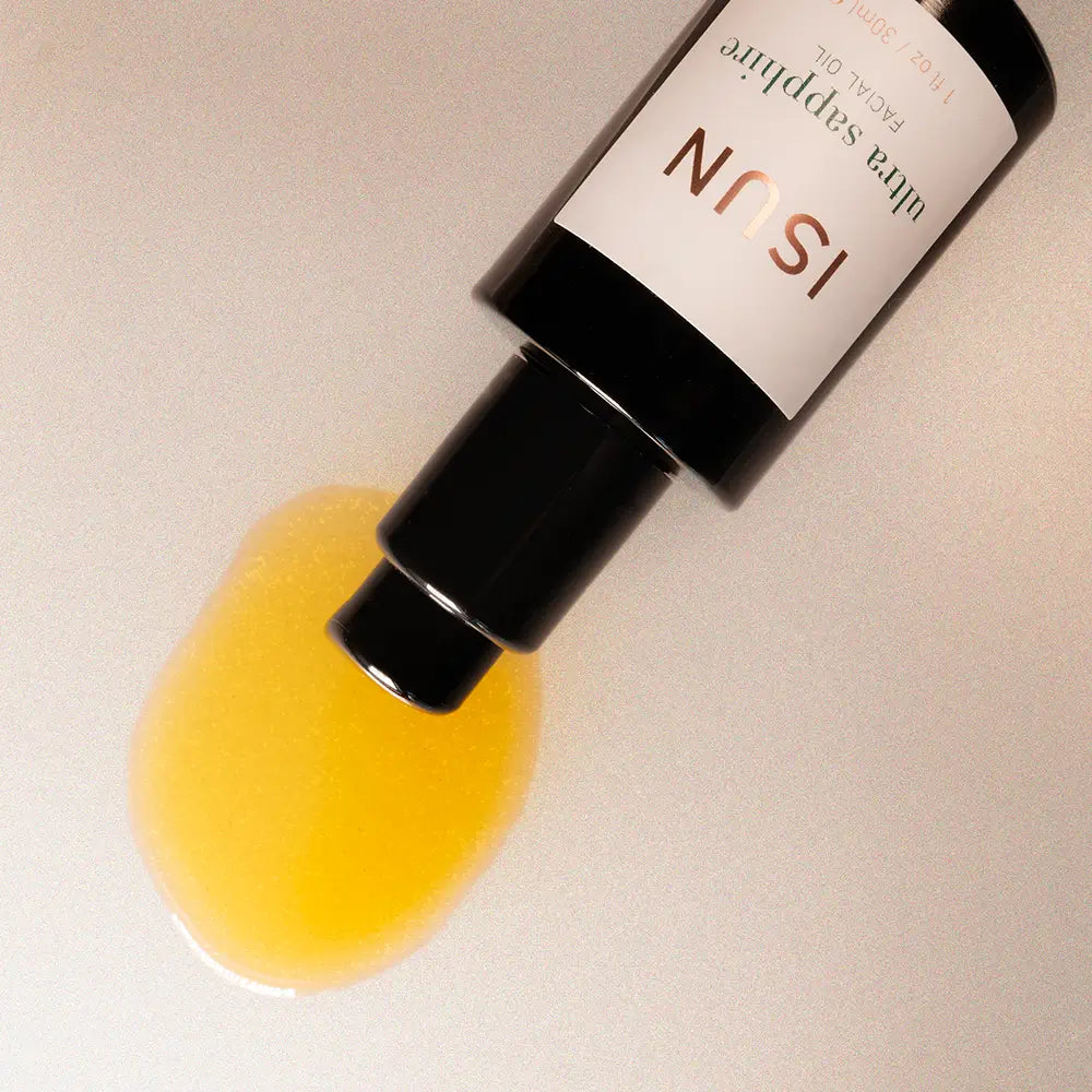 Skincare bottle with yellow liquid on a beige background