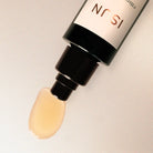 Cosmetic dropper with beige liquid on a light gray background, featuring the brand 'ISUN'.